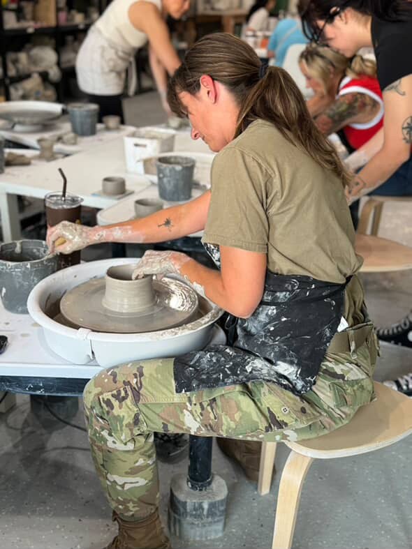 A person working with clay at a pottery wheel at Kask Studio